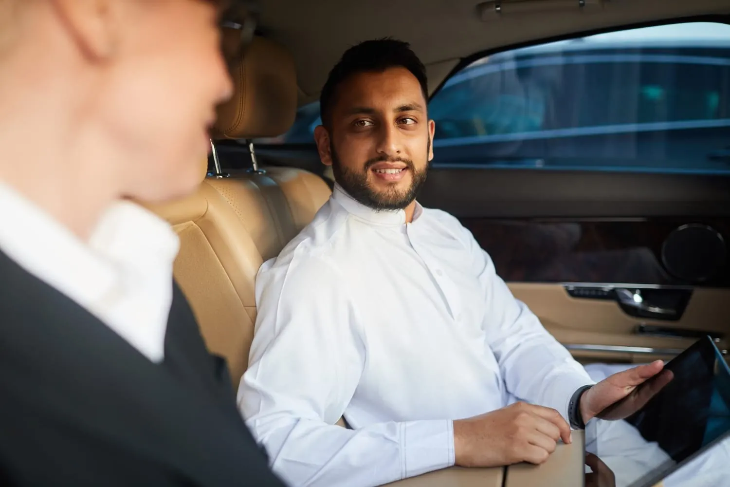 Business traveller working in the rear seat of a chauffeur-driven car